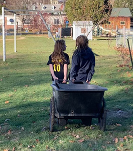 Two girls outside doing chores.